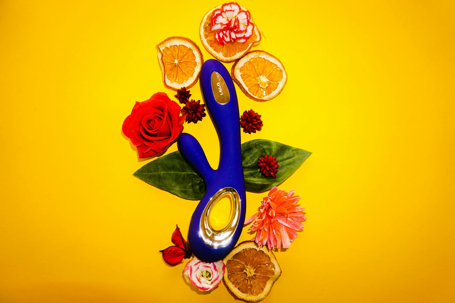 Vibratrice bleue entourée de fleurs et d'agrumes sur un fond jaune